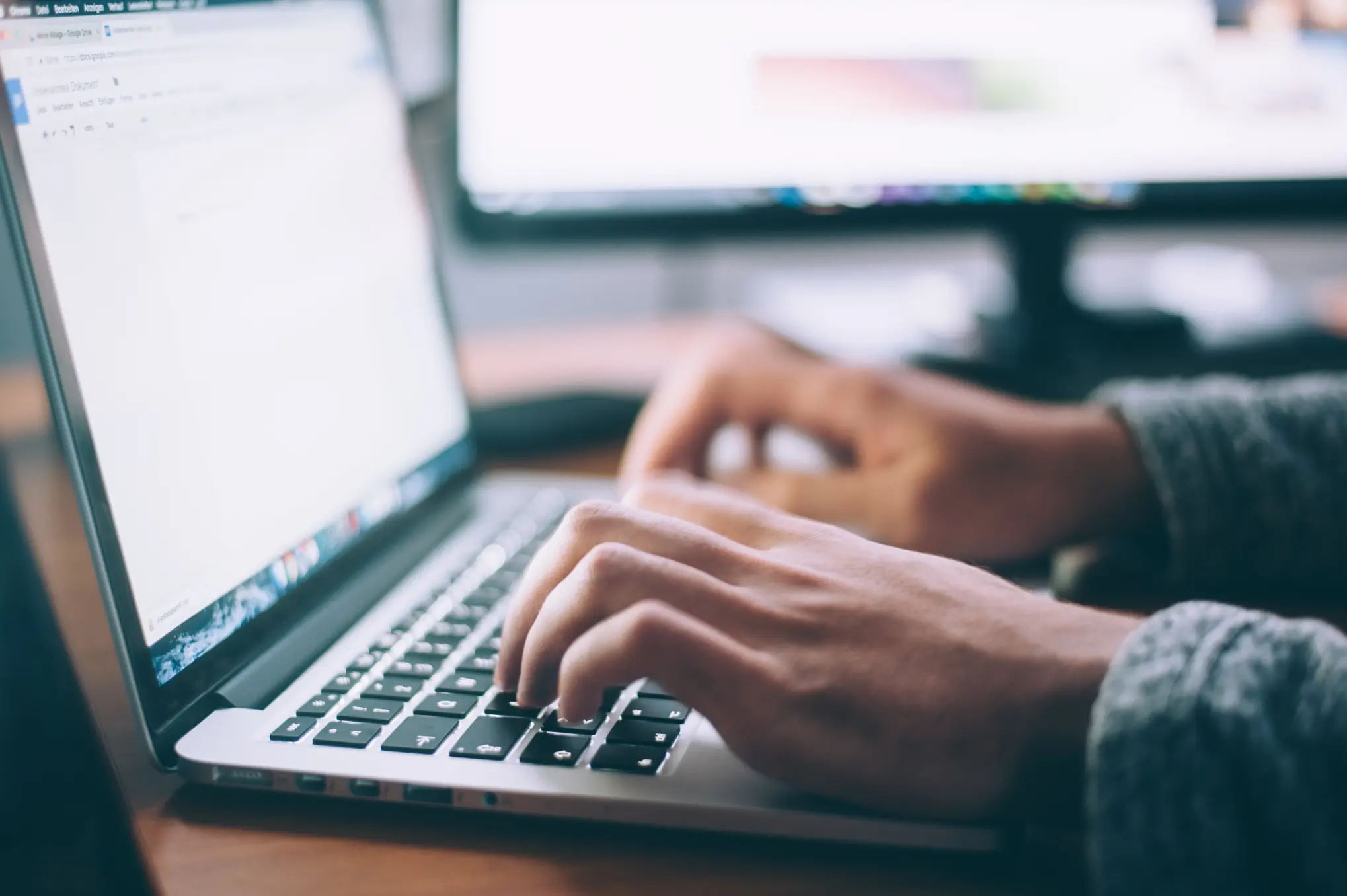 Person tippt auf Laptop-Tastatur